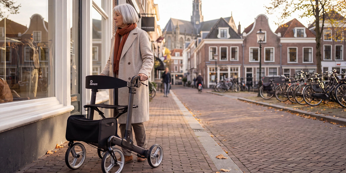 Parvum Luxo in antraciet in een oude winkelstraat; een vrouw staat stil en kijkt naar een etalage.