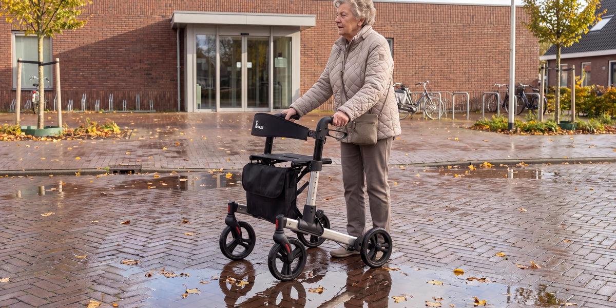 Parvum Riva in grijs voor de ingang van een buurthuis na een regenbui; een vrouw staat even stil.